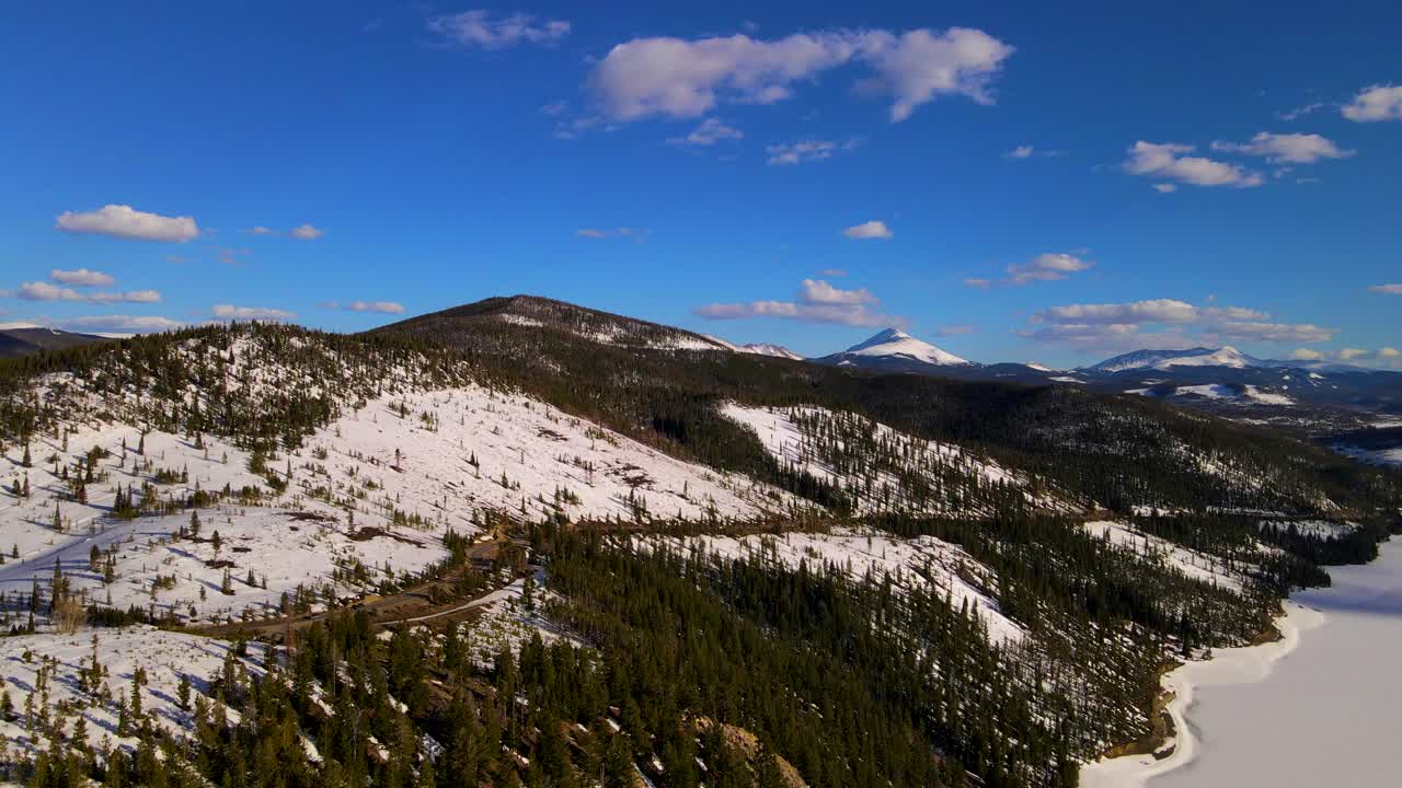 Snow covering landscape around Dillion reservoir on beautiful day. Aerial wide shot.