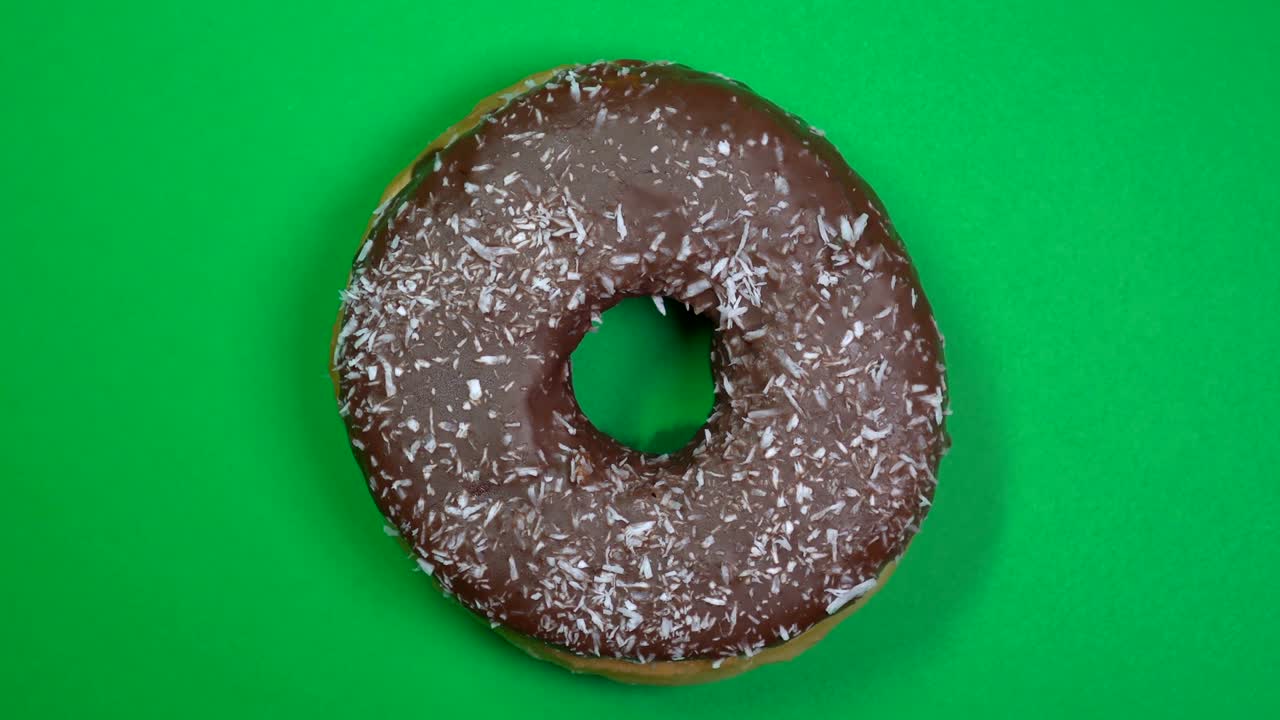 delicioso y fresco rosquilla de rosquilla macro disparo de primer plano girando sobre un fondo verde.