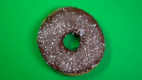 delicioso y fresco rosquilla de rosquilla macro disparo de primer plano girando sobre un fondo verde.