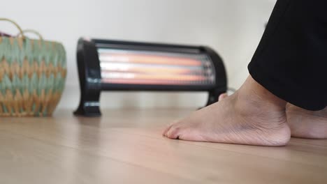 barefoot feet warming up near a heater