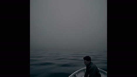 man in a boat on a misty sea