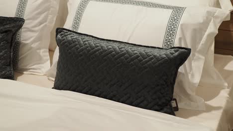 stylish dark gray pillow on a white bed