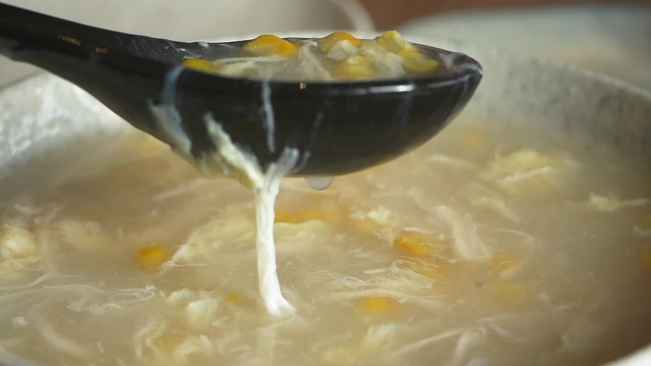 Nærbilde av kremet mais- og eggedropsuppe som øses opp
