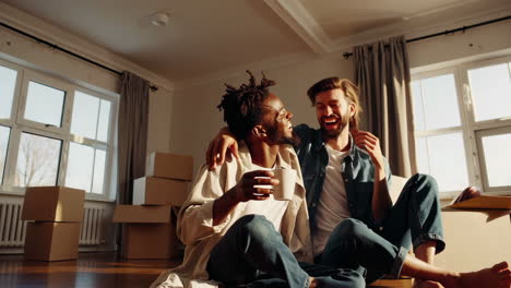 happy couple relaxing in new home surrounded by moving boxes
