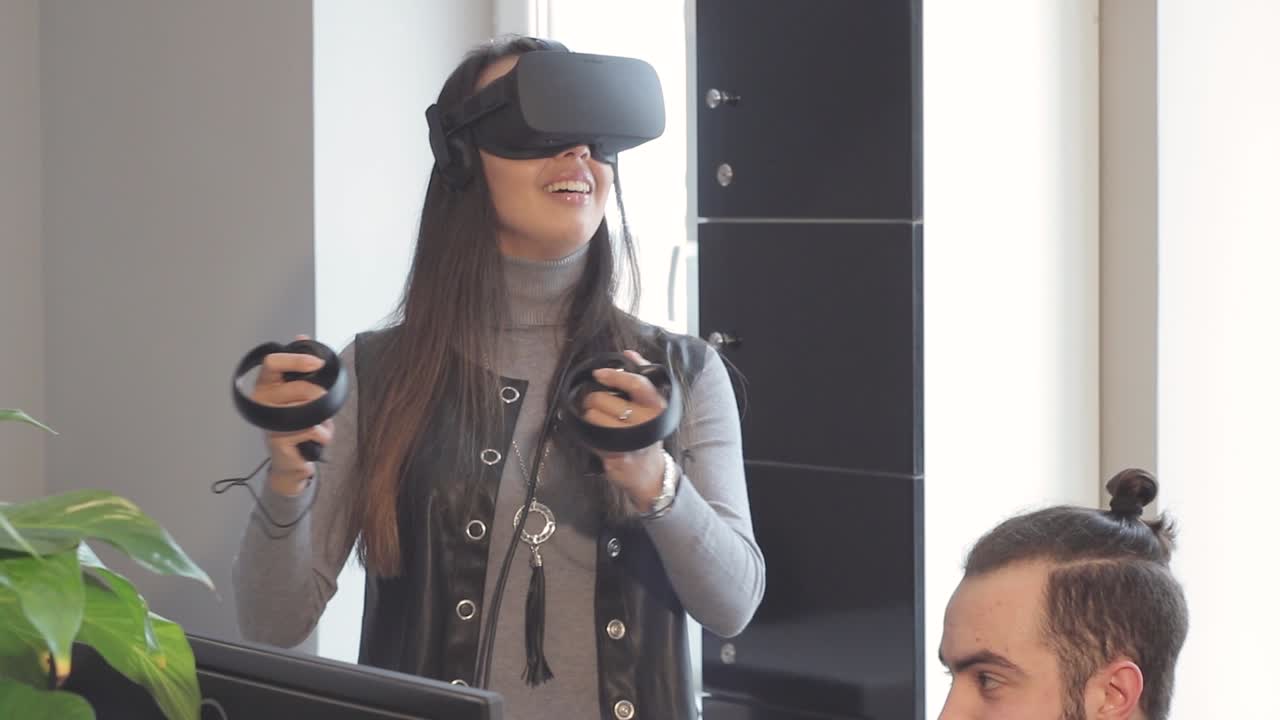 La bella ragazza che gioca con un visore di realtà virtuale in ufficio