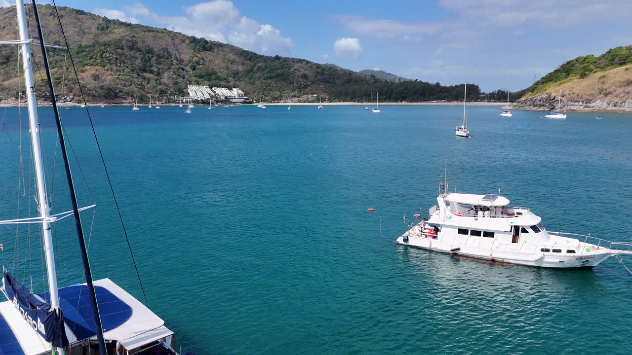 Aerial view of catamarans sailing in Phuket's turquoise waters, capturing the tranquil beauty of a tropical paradise