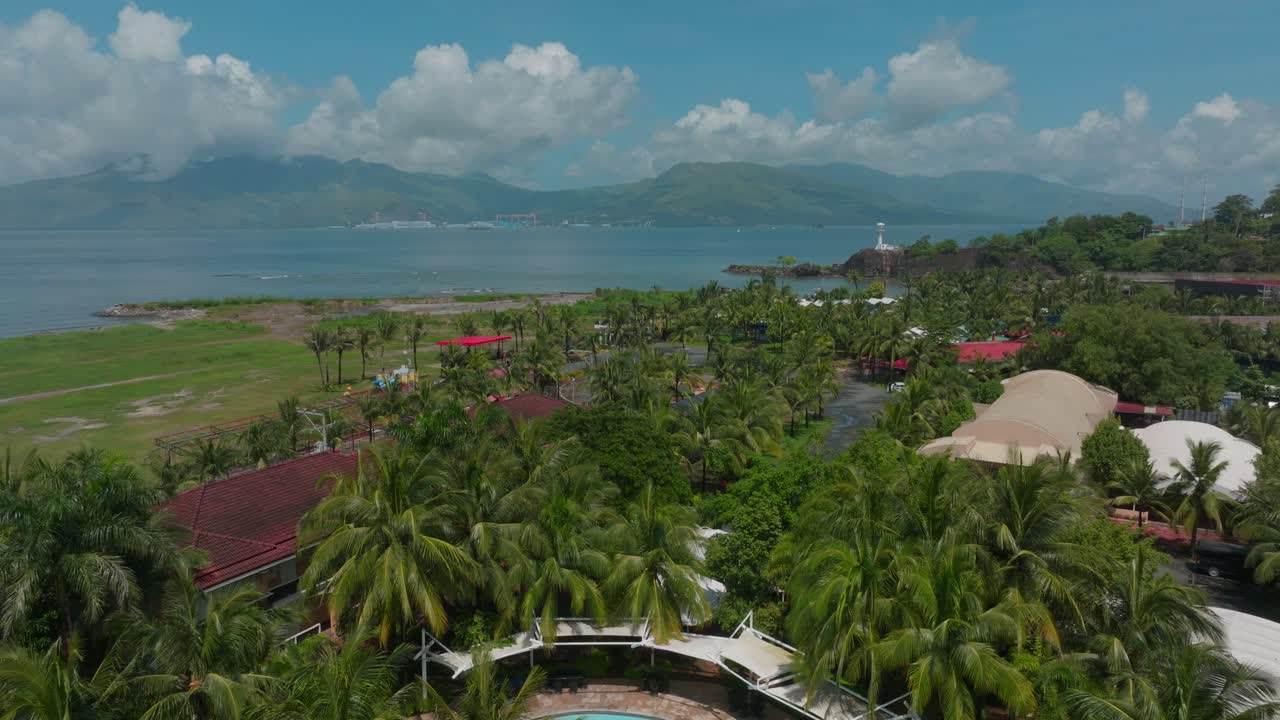 A stunning drone shot unveils a luxurious resort nestled along the coastline, where its elegant design meets the endless ocean view.
