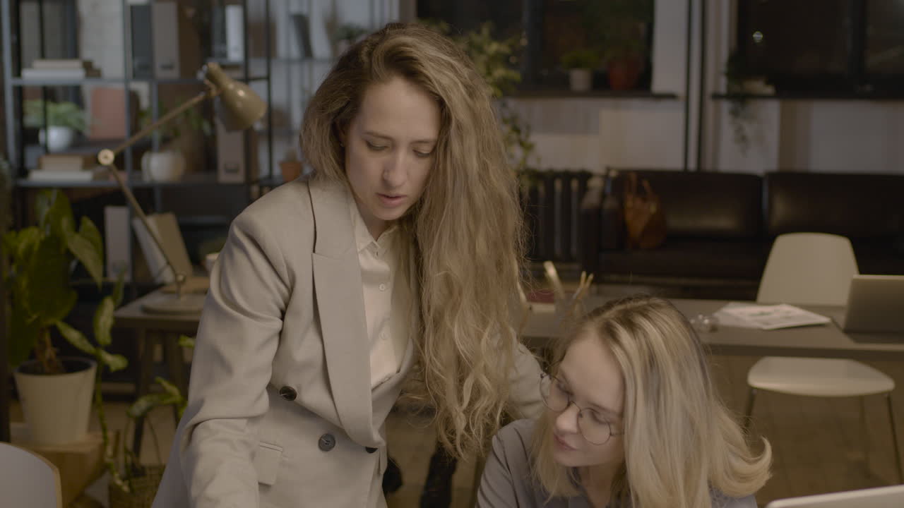 две сотрудницы разговаривают между собой и проверяют отчеты в офисе 1