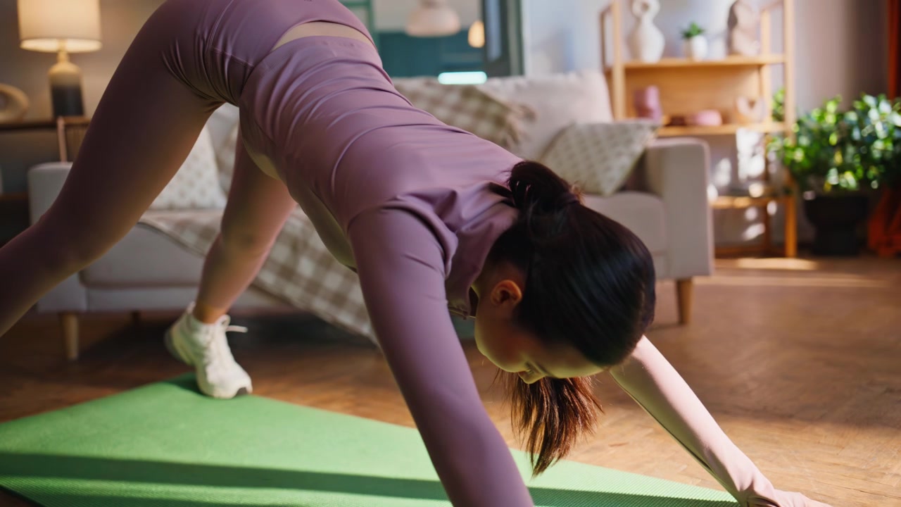Asian girl doing yoga stretches at home. Closeup fitness workout routine.