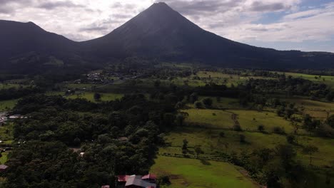 drone gimbal up revealing majestic huge arenal volcano in green environment