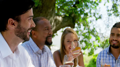 group of friends interacting with each other while drinking wine