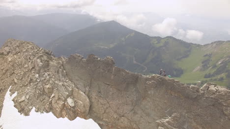 hikers rest atop a mountain ridge as the camera circles overhead