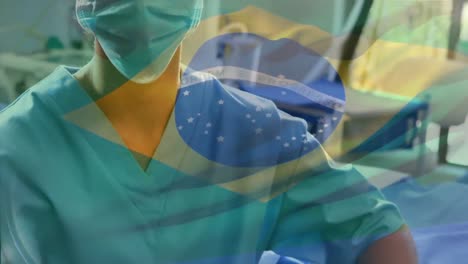 Animation-of-flag-of-brazil-waving-over-surgeon-in-operating-theatre