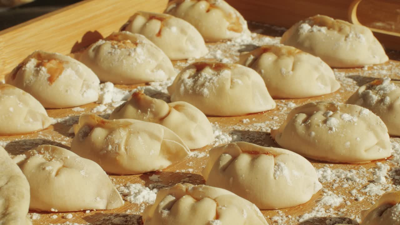 Chinese and Japanese Jiaozi or gyoza on wooden desk close-up. Dumplings with meat pouring red sweet chilli sauce. Cooking at cafe, restaurant. Asian street food market outdoors.High quality 4k footage