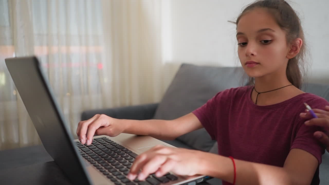 Primer plano de una chica escribiendo en un portátil mientras una persona a su lado le toca el brazo para llamar su atención; ella se detiene, mira para comprobar lo que está haciendo, luego sonríe y le da un pulgar hacia arriba en señal de apoyo.
