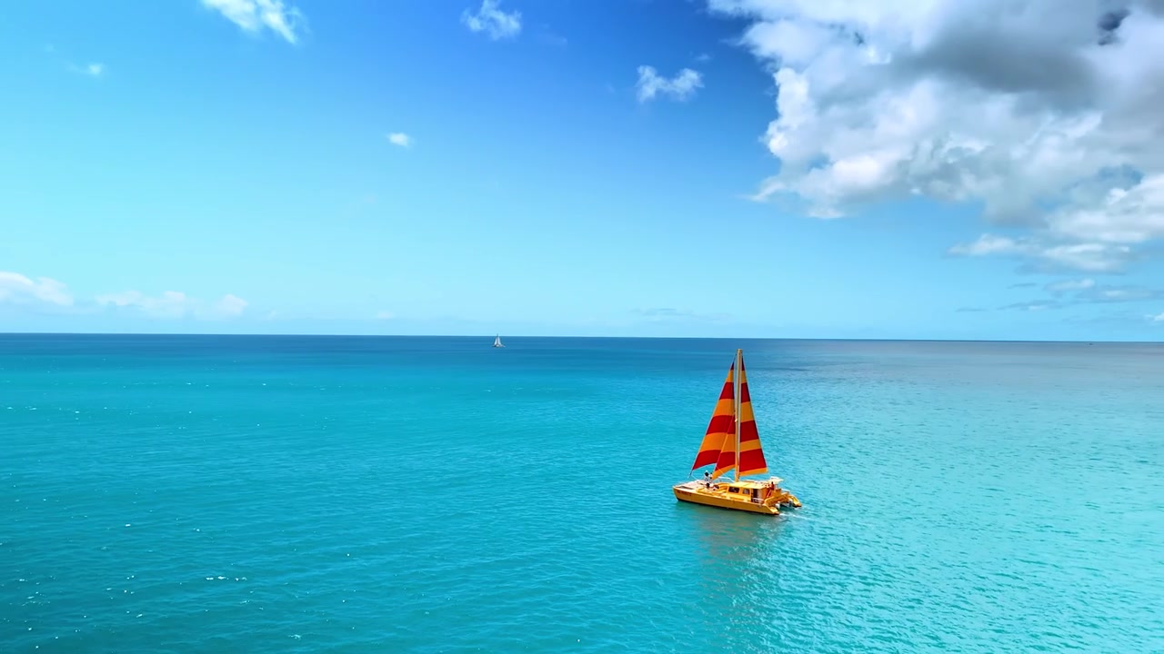 Incredibile e calmo paesaggio marino turchese dell'Oceano Pacifico. Riprese con drone attorno alla barca a vela gialla che si muove sulla superficie dell'acqua