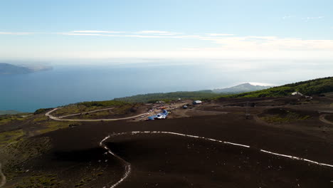 Osorno Volcano ski resort overlooking vast Lake Llanquihue, volcanic slopes, winding road, Chile. Aerial drone panoramic view, copy space
