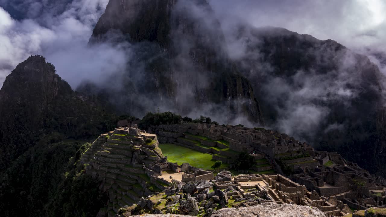 Time lapse view of the ancient Inca ruins of Machu Picchu covered in mist and clouds high in the Andes mountain range, Cusco Region, Peru.