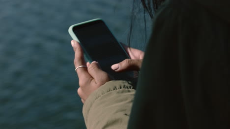 close up woman hands using smartphone texting sending messages chatting online social media sharing digital communication on mobile phone in seaside