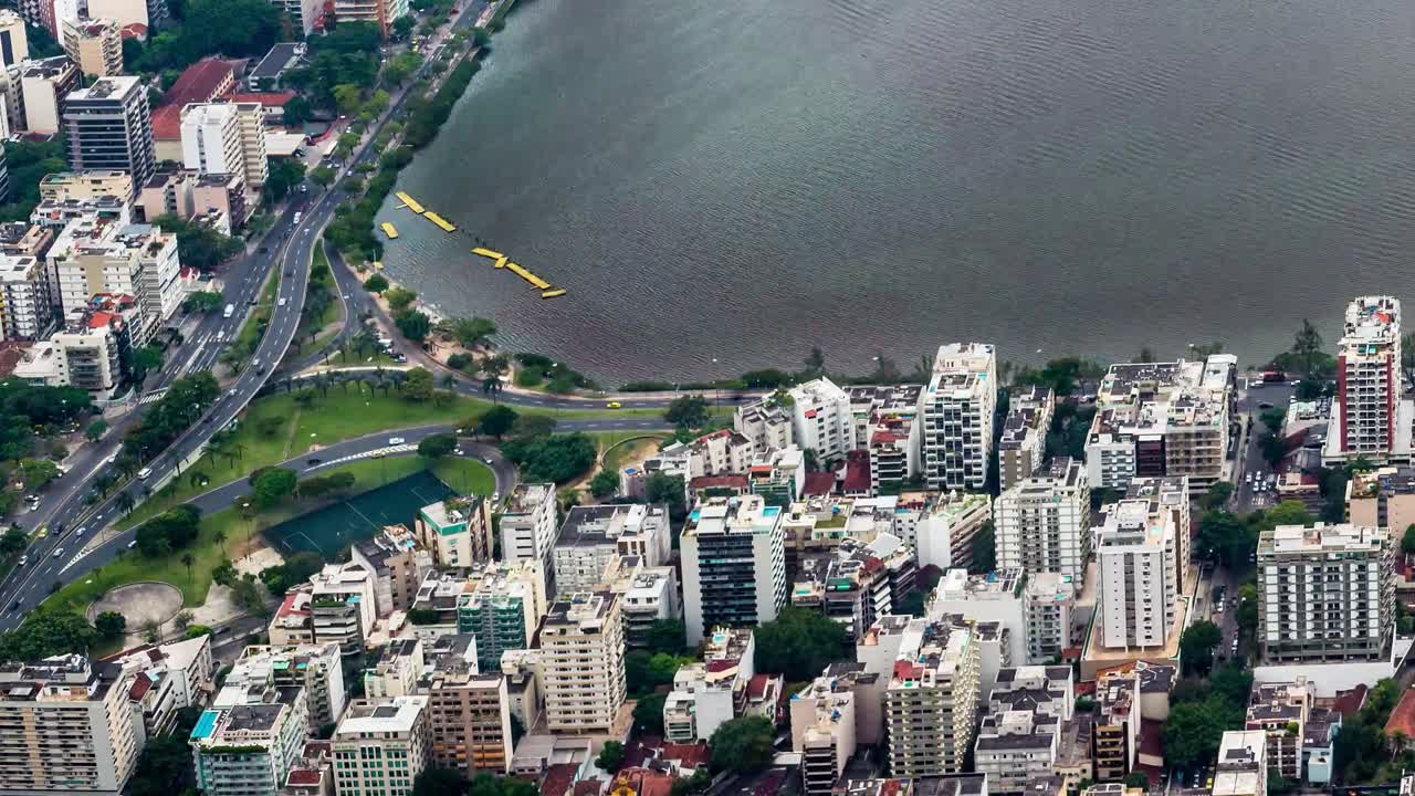 Filmato time-lapse di un'area urbana densamente popolata lungo una laguna. Numerosi grattacieli residenziali e commerciali dominano lo skyline, con strade e traffico visibile