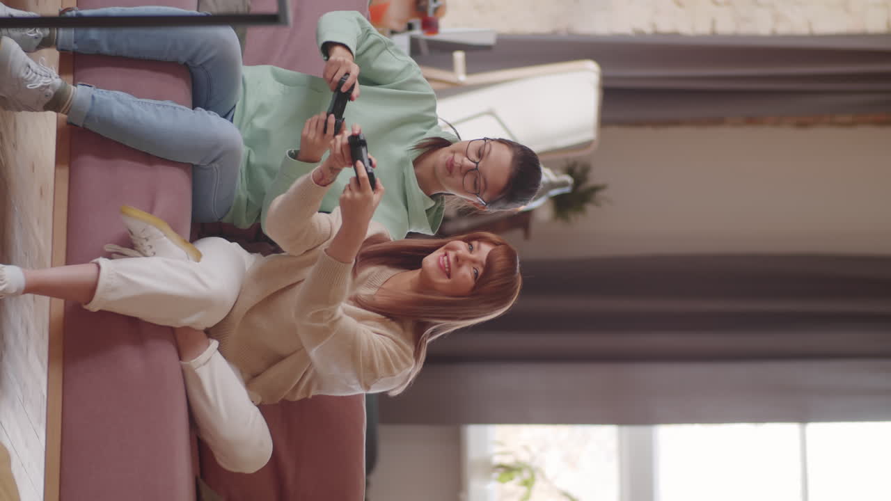 십대 딸 과 함께 콘솔 게임 을 하는 즐거운 어머니