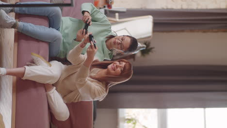 madre alegre jugando a un juego de consola con su hija adolescente