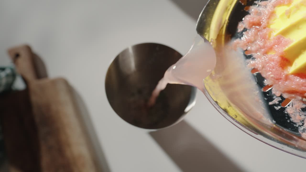 Versare succo di pompelmo nello shaker per cocktail, inquadratura dall'alto 4K.