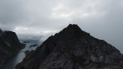 Volando-A-Lo-Largo-De-Una-Cresta-De-Montaña-En-Noruega,-A-La-Derecha-No-Hay-Vista-A-Través-De-La-Niebla-Y-A-La-Izquierda-La-Vista-Del-Océano-En-El-Fondo,-En-Cámara-Lenta