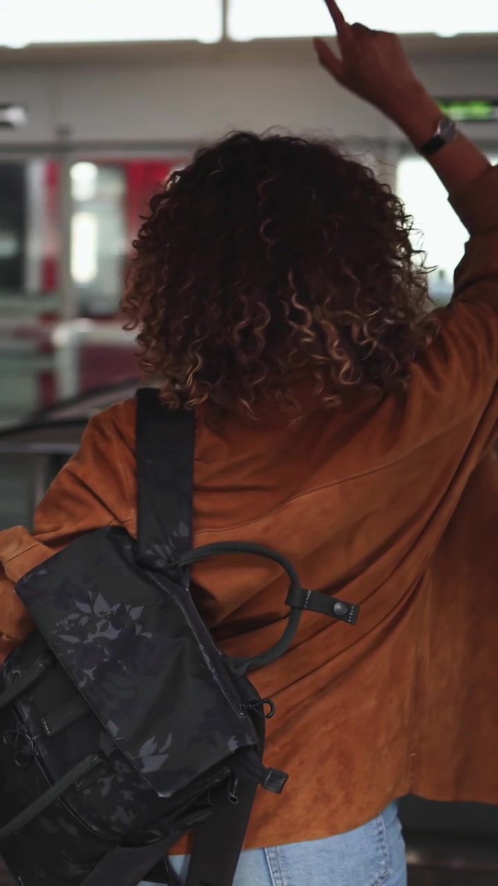 Young Woman with Headphones and Backpack in a Public Transport Station
