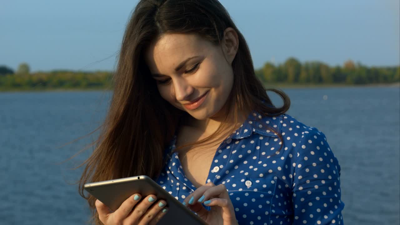 Mujer al aire libre usando una tableta digital. Primer plano