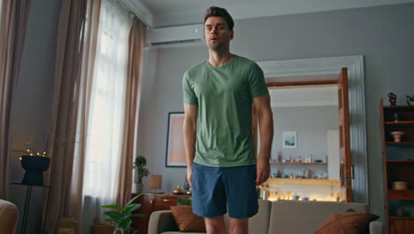 athletic man workout home. focused strong guy doing forward lunge exercises
