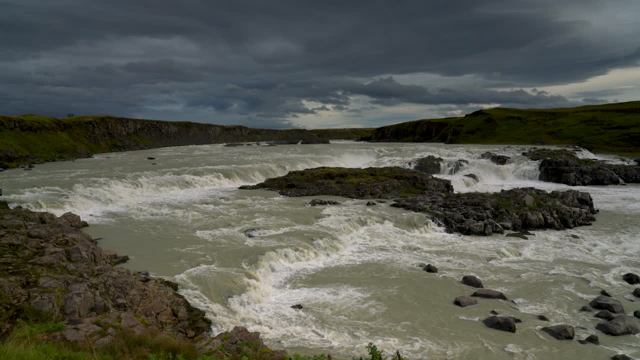 Aerial view of Urridafoss waterfall and Thjorsa river at grey cloudy day in Iceland. Wide shot. Green mossy landscape in summer,