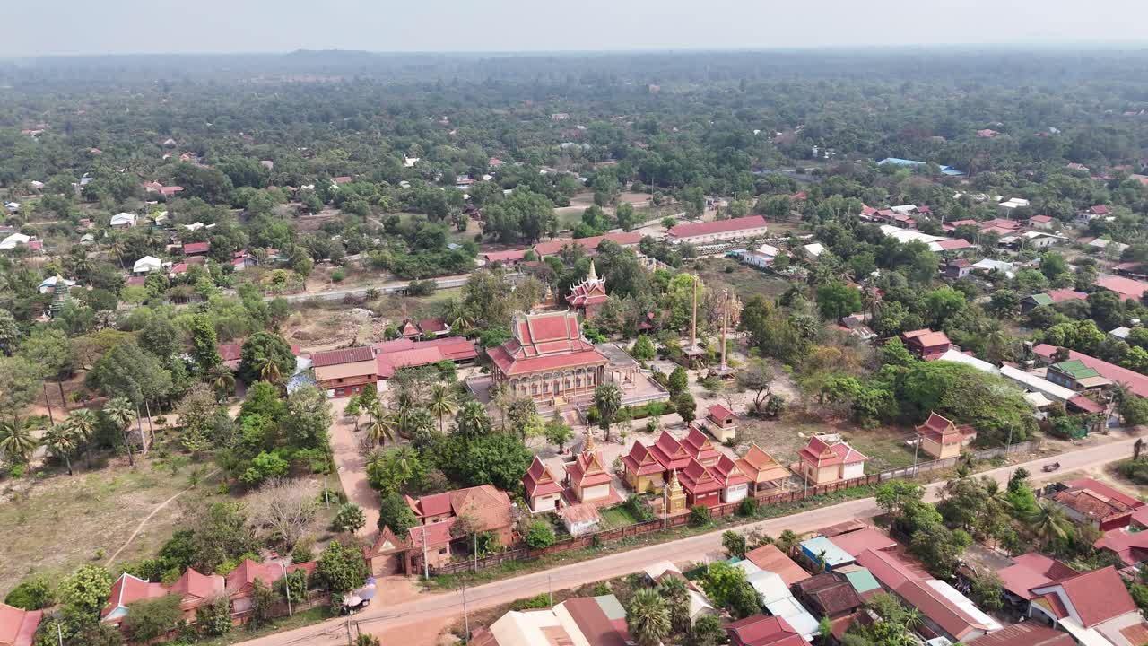 This aerial view captures a temple complex, likely in Southeast Asia given the architectural style, possibly Wat Preah Vihear based on the context. The temple features tiered roofs with ornate