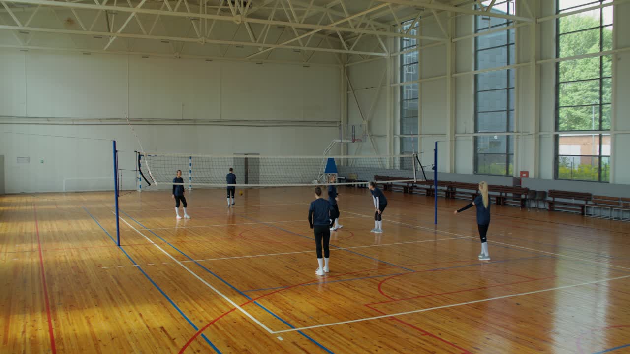 Volleyballhold træner i et gymnasium