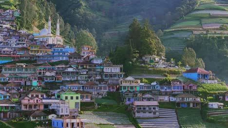 aerial view of colorful hillside village with a prominent white mosque nestled in a tropical mountainslope landscape, nepal van java, mount sumbing, indonesia