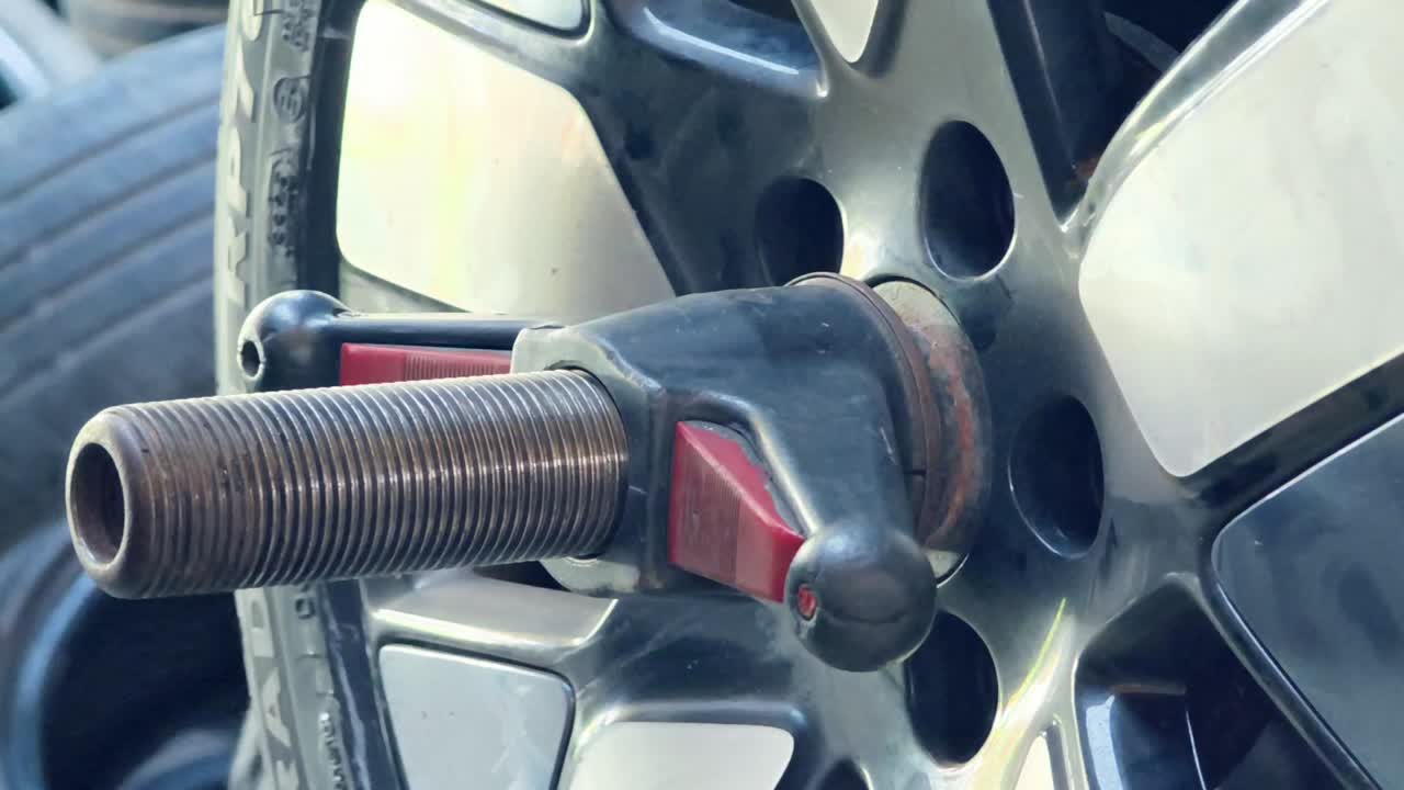 Mechanic's Hand Adjusting Car Wheel on Tire Balancing Machine