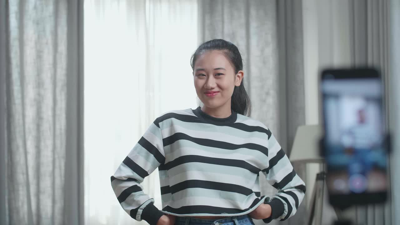 Asian Woman Dancing While Shooting Video Content For Social Networks With A Smartphone Camera