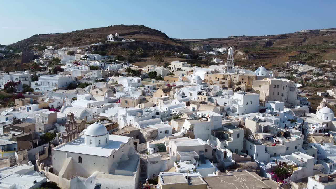 Aerial view of Santorini island traditional famous classic cliffside white houses overlooking The Mediterranean Sea on a beautiful summer day