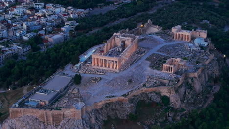 tight circling aerial shot of the acropolis lit up