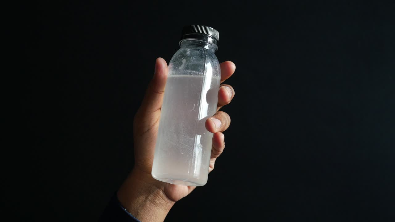 mano con una botella de plástico de agua