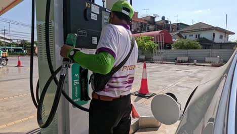 attendant refueling a vehicle at a gas station