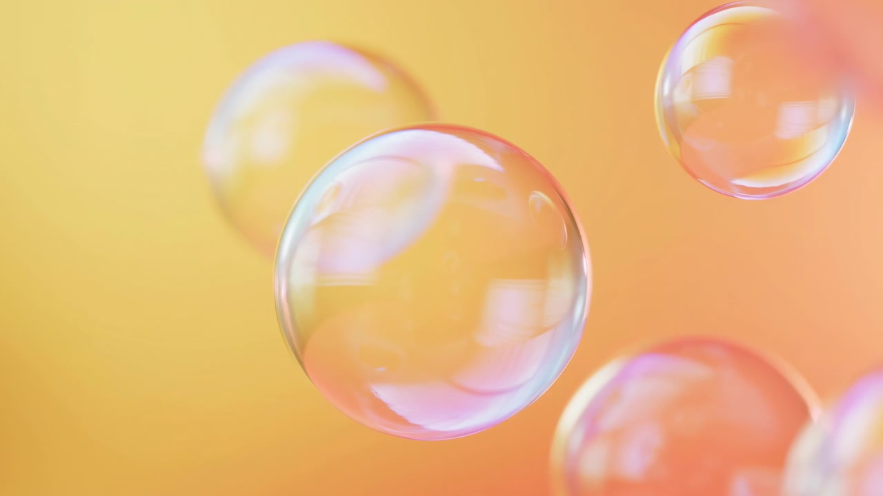 Large translucent soap bubbles float in close-up over smooth warm gradient background blending pale yellow, peach, and soft orange, creating dreamy abstract motion with gentle light and delicate