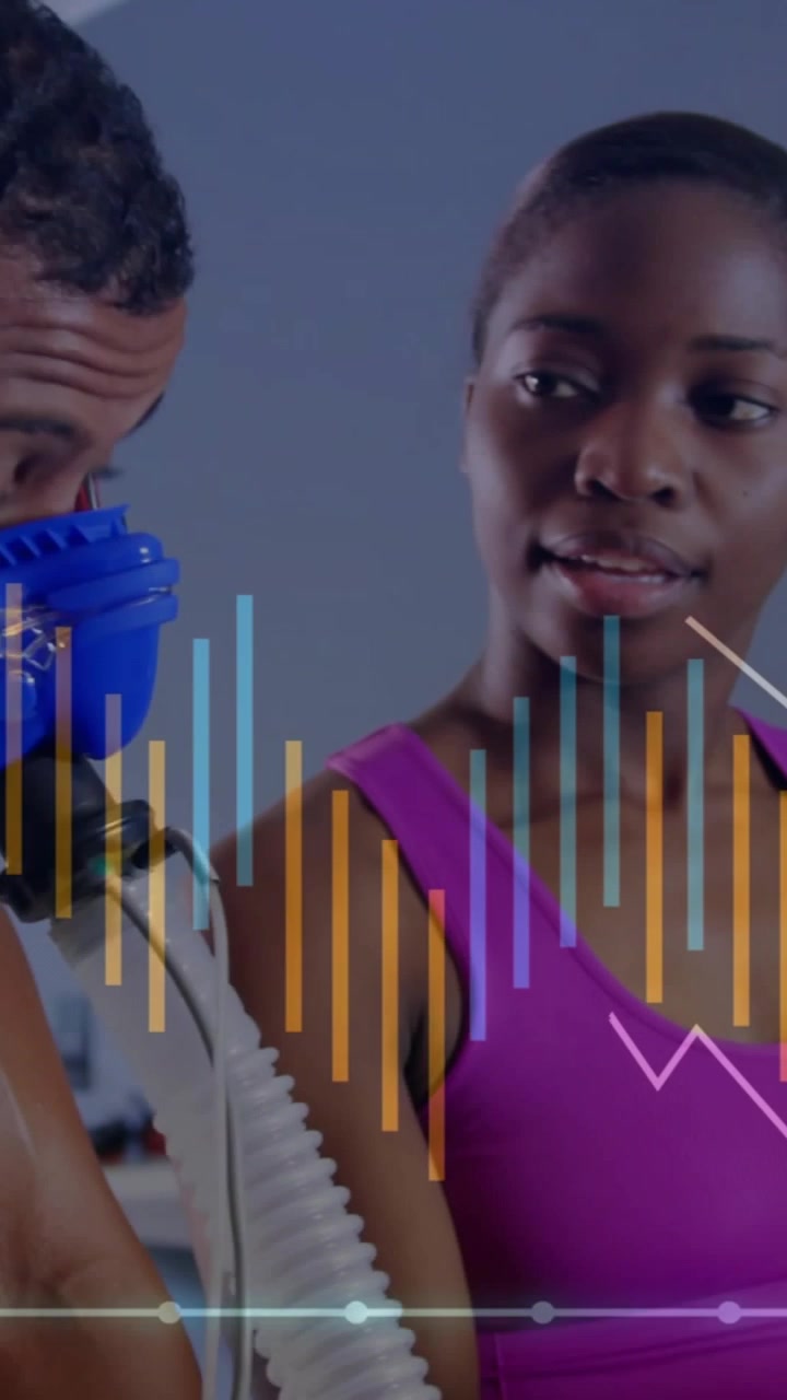 Vertical video: Tech fitting blue mask man fixing hose pad showing fitness graphs over man for test