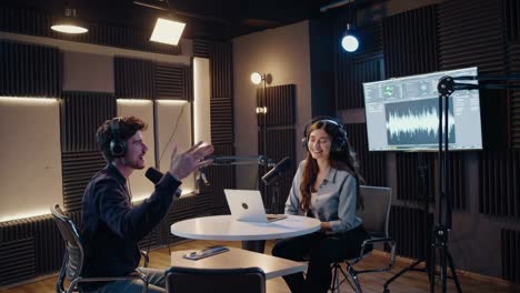 a modern podcast studio with two hosts recording a video. shot from a side angle