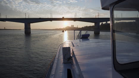 view from a boat approaching a city bridge at sunset