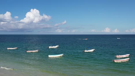 low altitude slow forward tracking drone shot of boats moored on beach