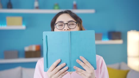 fun young woman looking behind book.