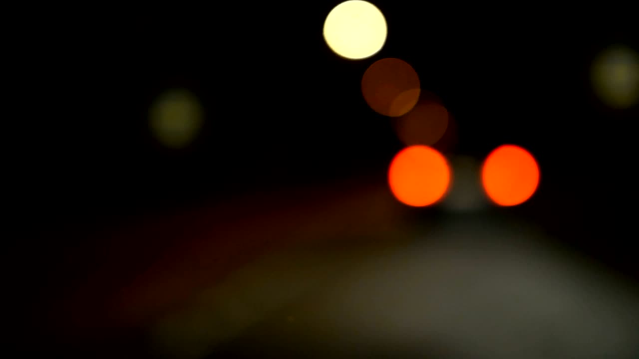 conducir un coche a través de la carretera de la noche, la autopista. luces desenfocadas calle de los ángeles resumen. ciudad fondo borroso. movimientos círculos bokeh de tráfico nocturno.