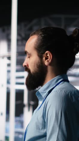 vertical video close up of developer in data center coding with generative ai on laptop