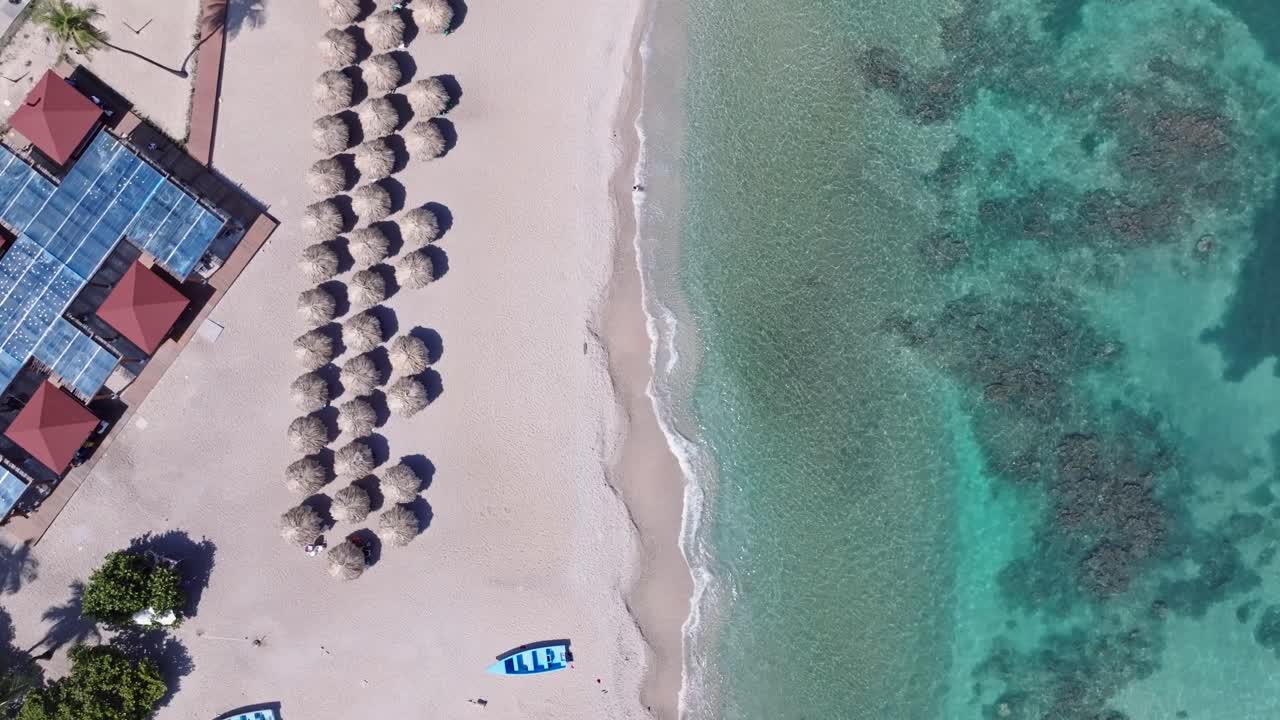 fotografía aérea de arriba hacia abajo de sombrillas en la playa de arena de quemaito y agua de mar clara en verano